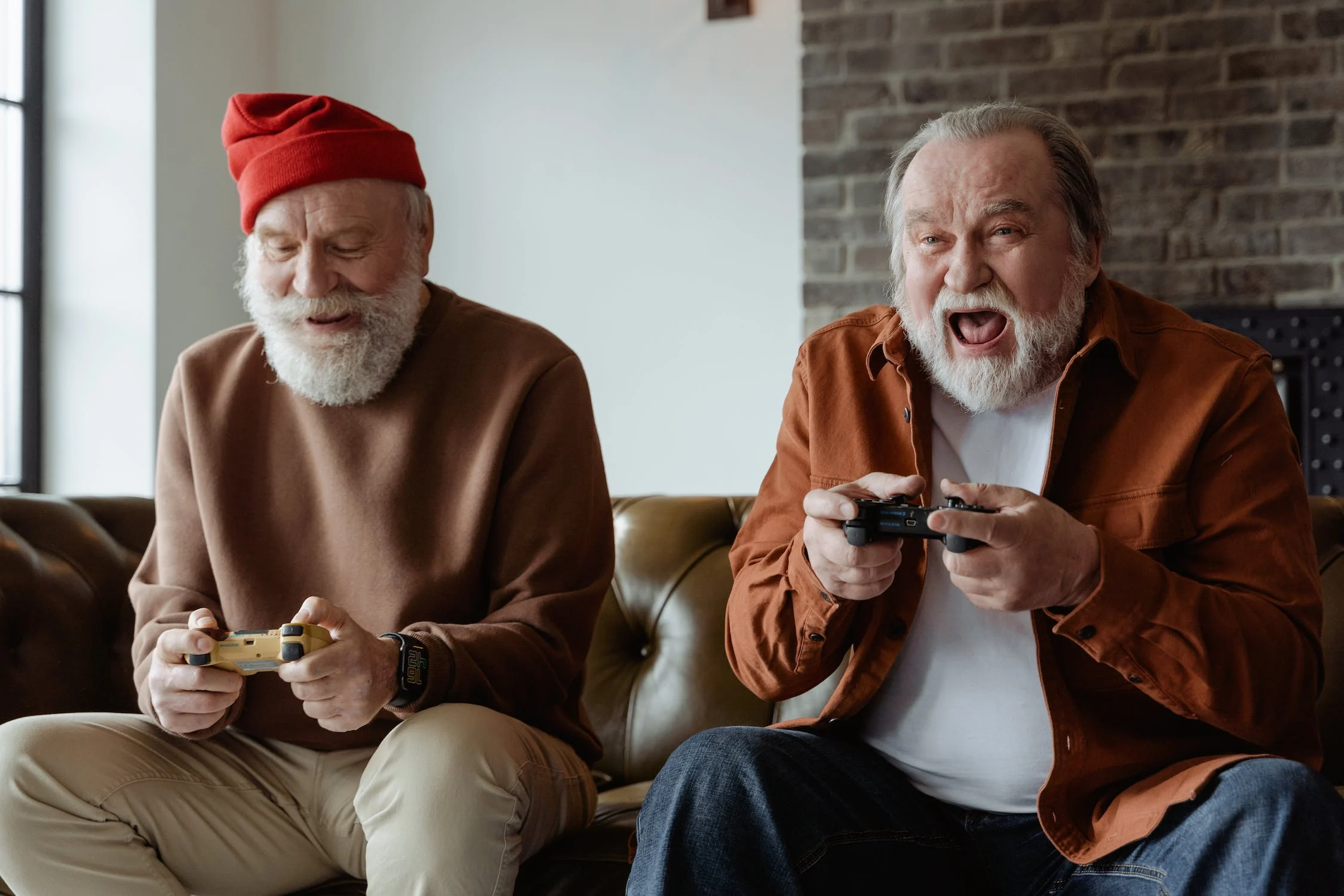 Two seniors enjoy a video game together at their senior housing, assisted living